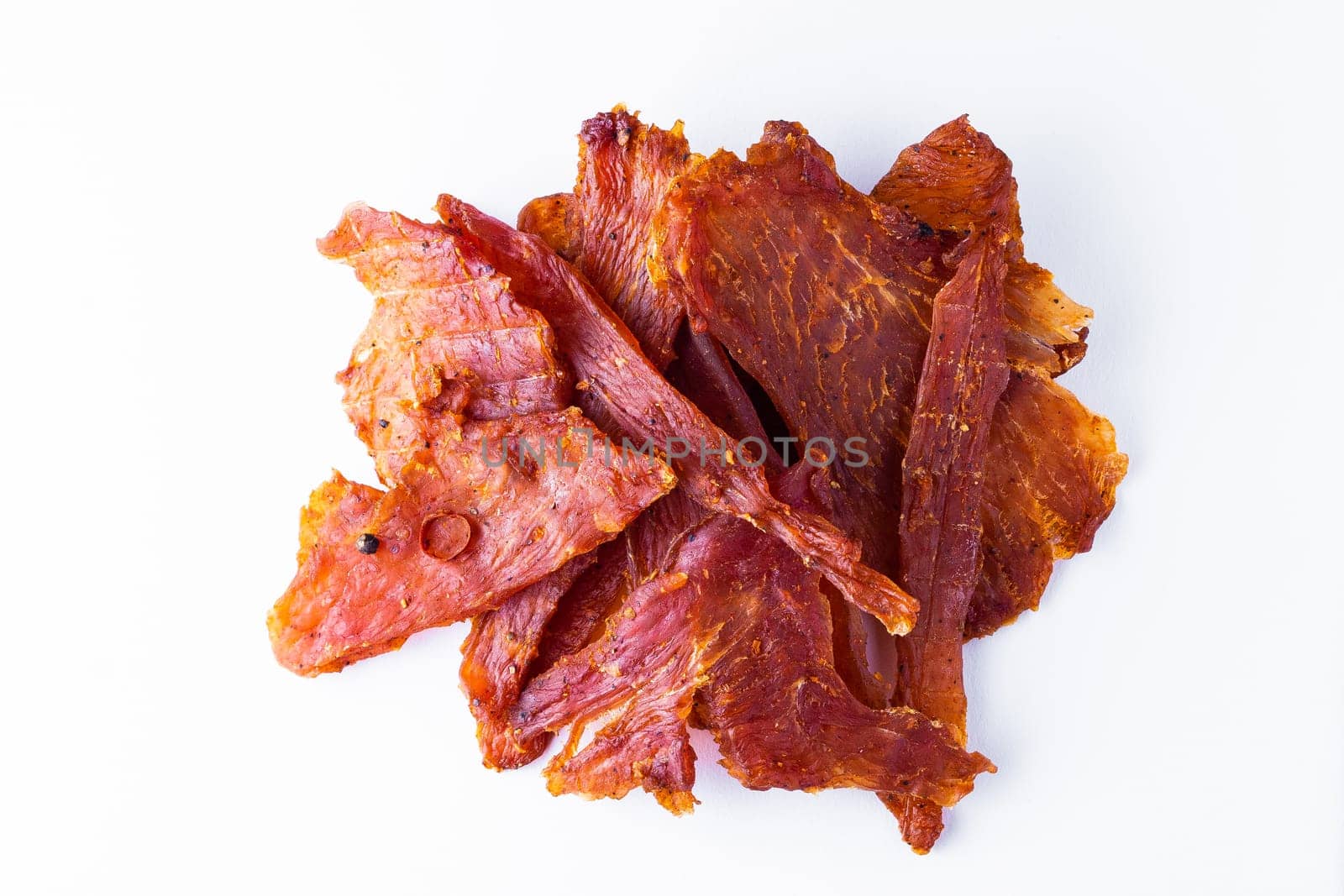 Beef jerky pieces isolated on a white and black background by Zelenin