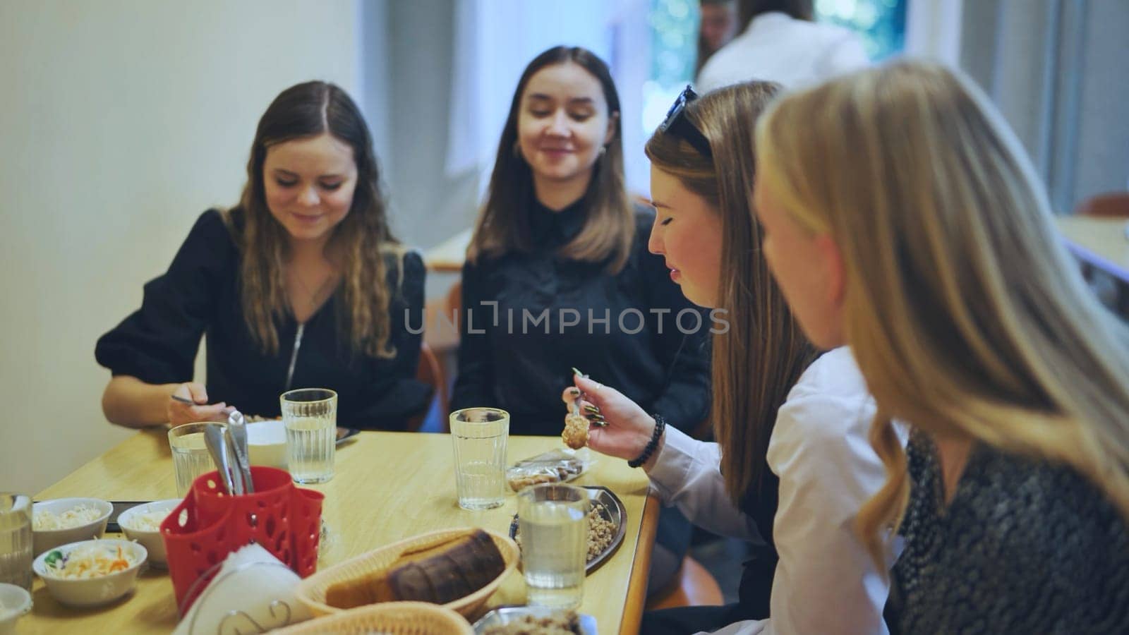 High school students eat in the cafeteria. by DovidPro