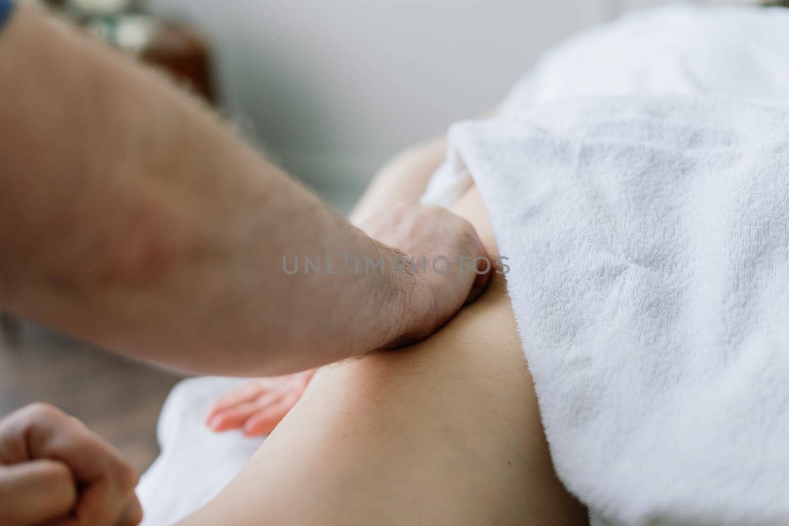 A woman receiving a belly massage at a beauty salon by Zelenin