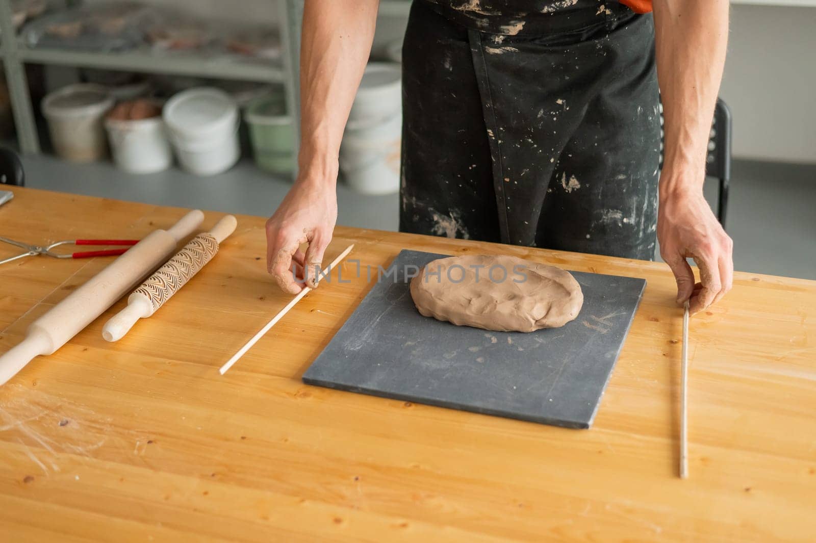 Close-up of potter's hands rolling out clay