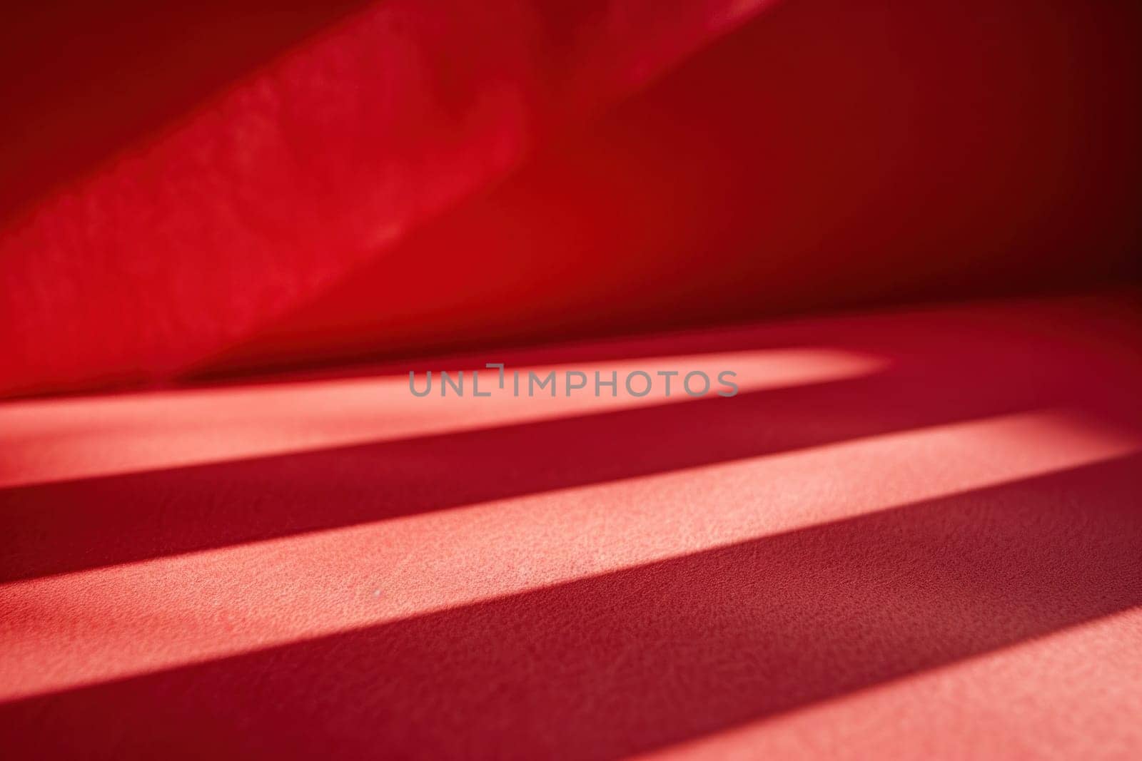 Comfortable red couch with sunlight shining through window, creating shadows on wall in cozy living room interior