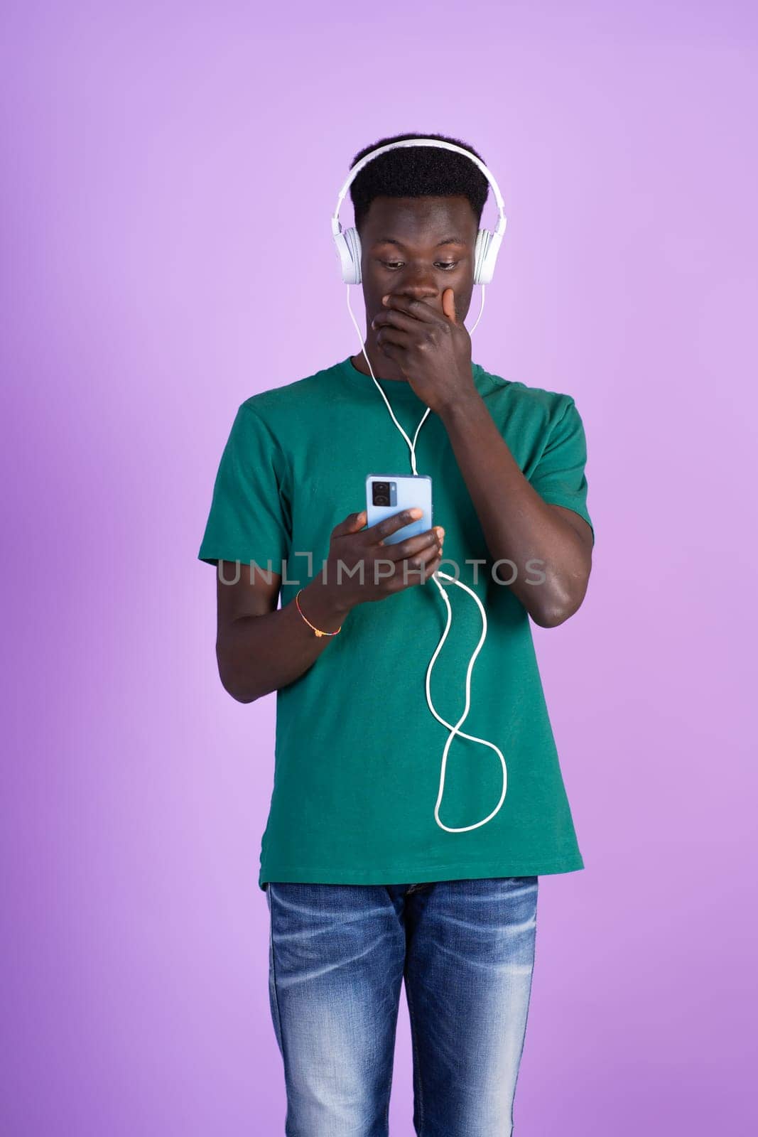 A man wearing headphones is immersed in listening to music, with a focused expression on his face.