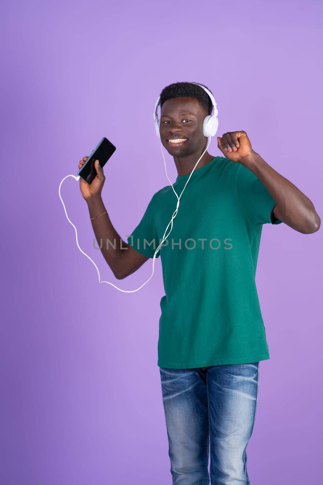 Man Wearing Headphones and Holding Remote by Ceballos