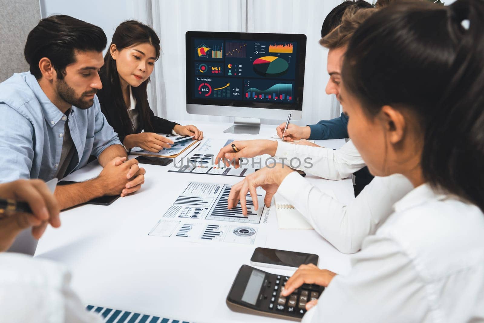 Diverse corporate audit team or company bookkeeper and accountant consultant calculate account expenses and income budget for tax refunds using calculators in busy workspace. Prudent