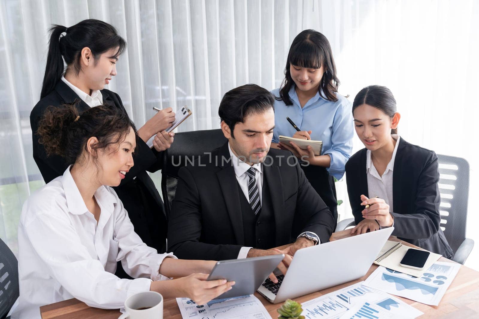 Diverse group of business analyst team analyzing financial data report paper on office table. Chart and graph dashboard by business intelligence analysis for strategic marketing planning Meticulous