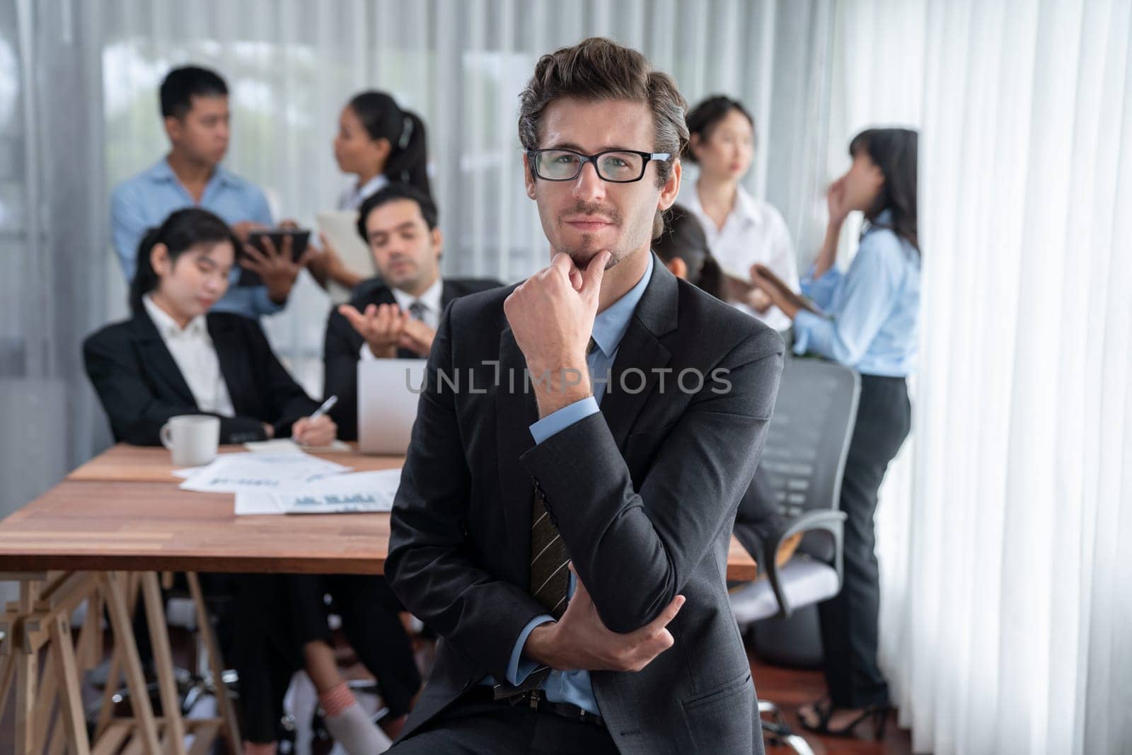 Portrait of happy businessman looking at camera with motion blur background of business people movement in dynamic business meeting. Habiliment