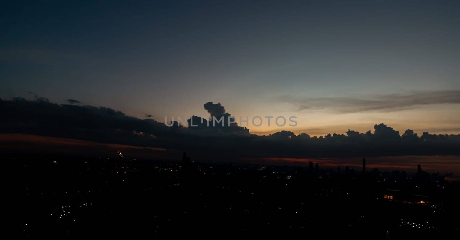 Twilight sky in the Evening with dark clouds on silhouette of the city. Silhouette of skyline view, Natural atmosphere night sky, Space for text, Selective focus.