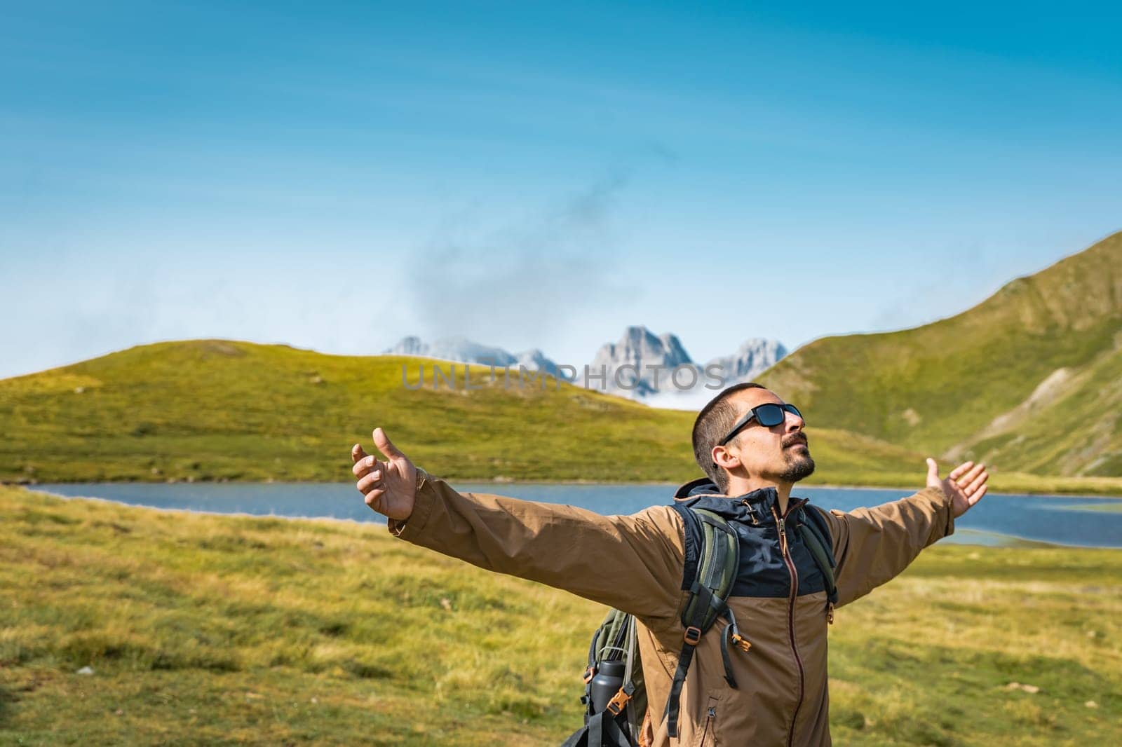 Young traveler with backpack raised arms hiking outdoor happy. Travel Lifestyle Adventure concept. High quality photo