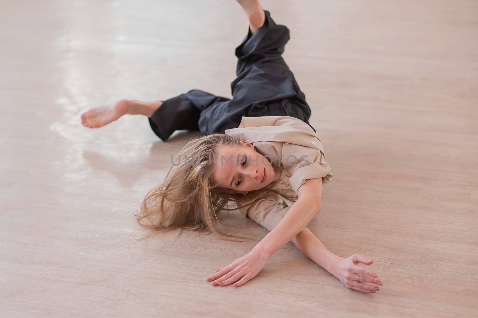 Caucasian woman dancing contemporary on the floor in a ballet class. by mrwed54