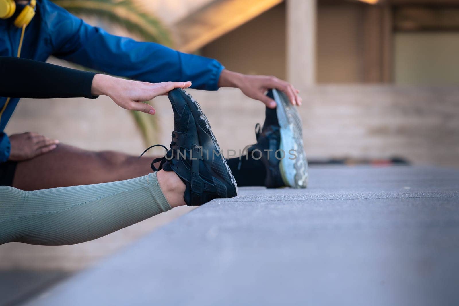 Active and fit male and female runners in leg warm-up stretching for running or cardio outdoors