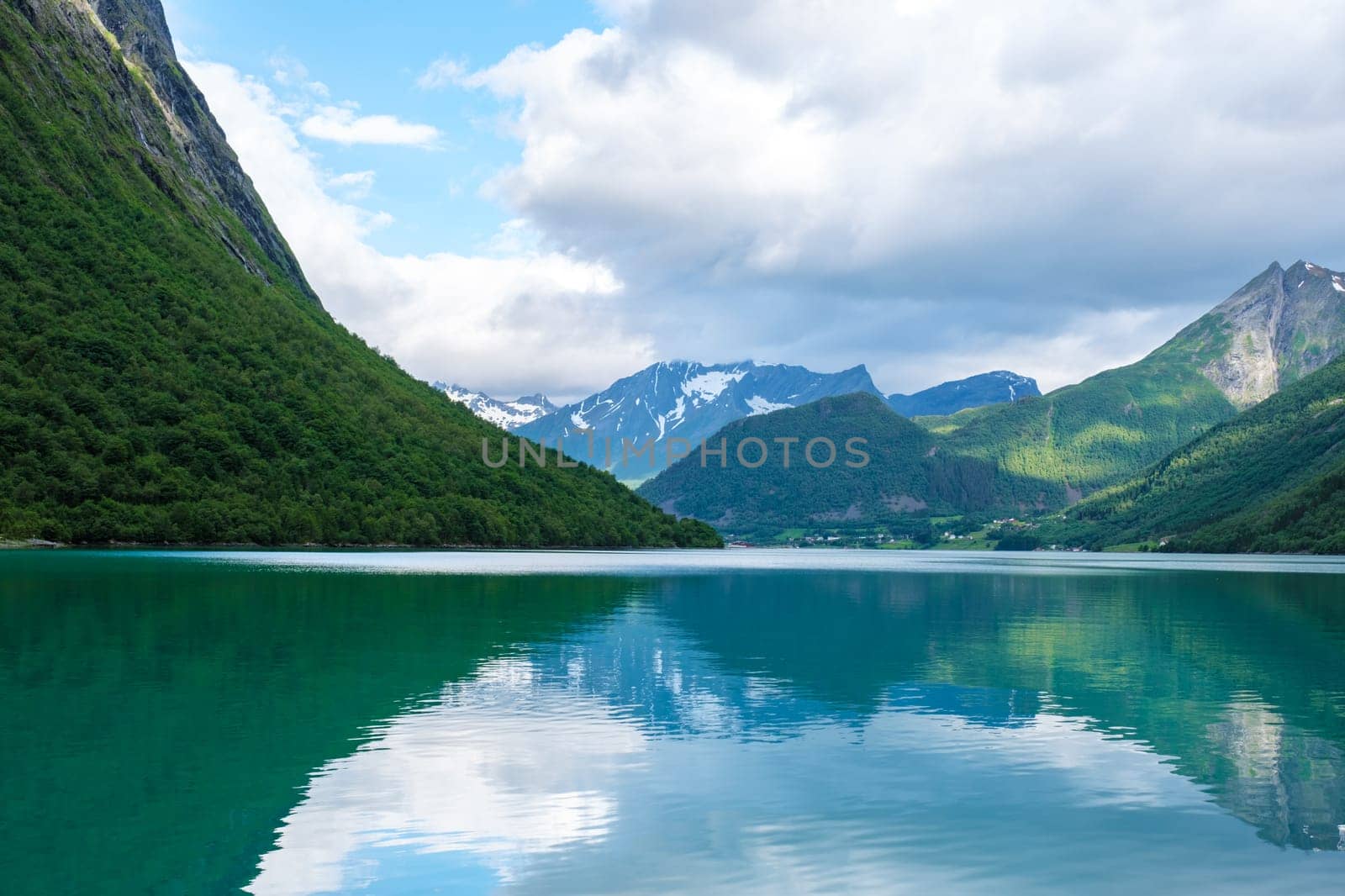 A tranquil fjord in Norway, with calm waters reflecting the surrounding mountains and sky. a picturesque scene, showcasing the beauty of the Norwegian landscape. Norangsfjorden Norangdal Urke Norway