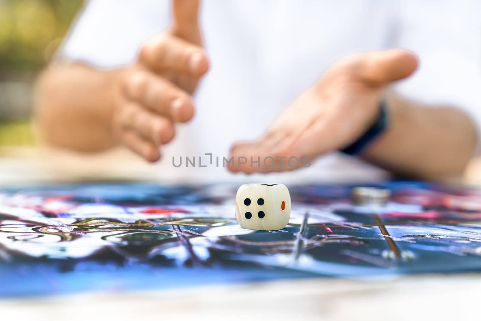 Man Playing Ancient Indian Board Game Leela: Spiritual Dice Roll, Close-up of men's Hands, Focus on Cube. by Laguna781