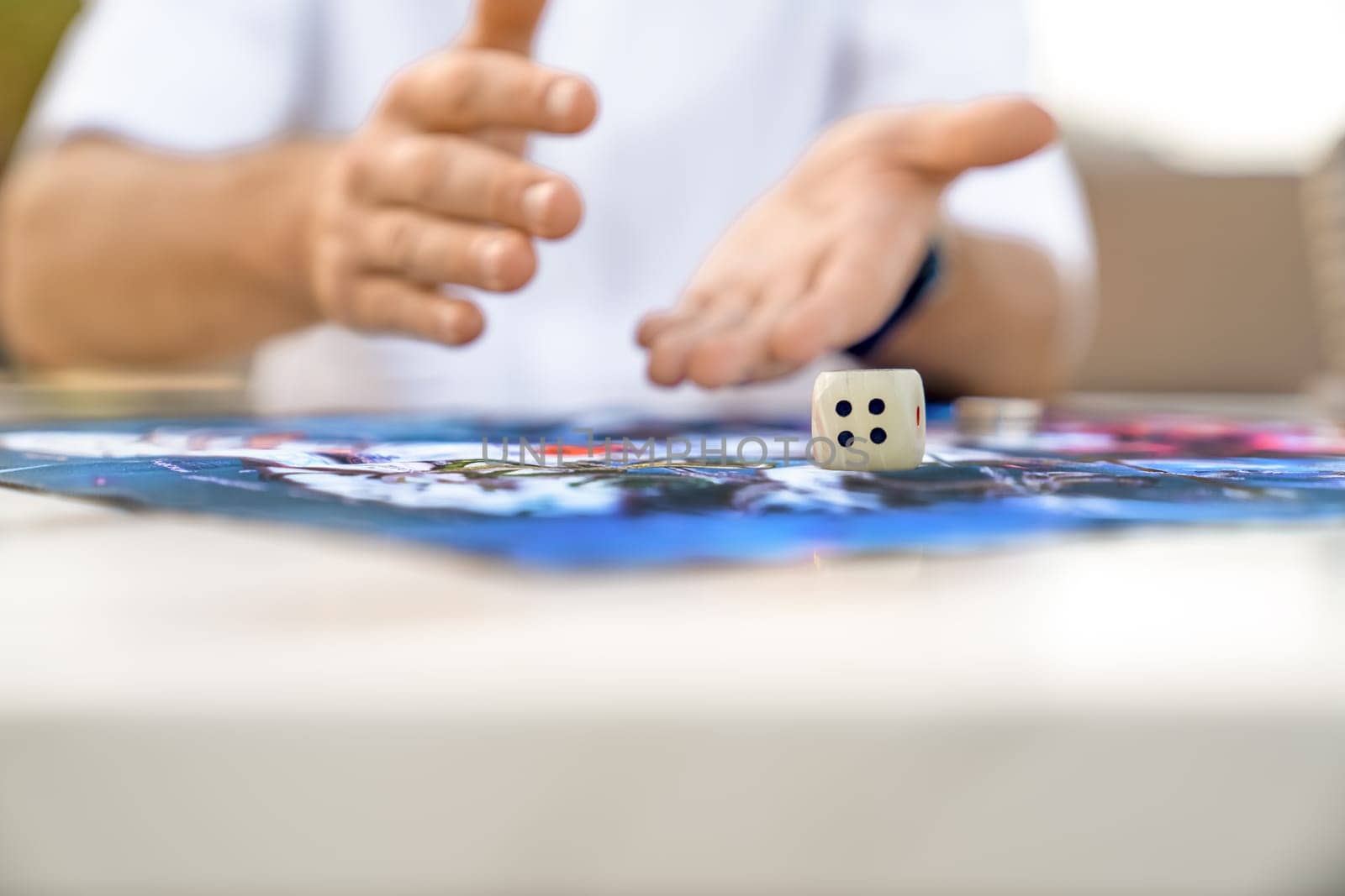 Man's Hand Throws Die onto Paying Field, Close-up, Copy Space.