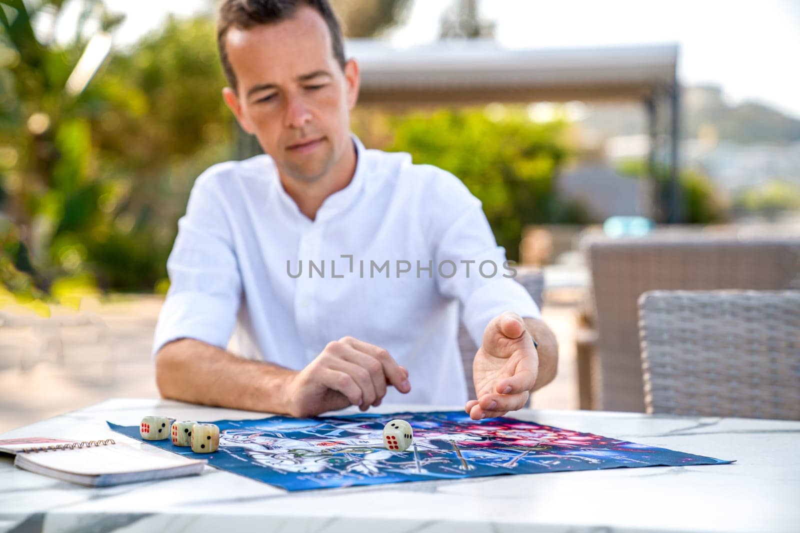 Turkey, Alanya - April 14. Portrait of Man Playing Ancient Indian Board Game Leela, He Makes Roll of Dice. by Laguna781