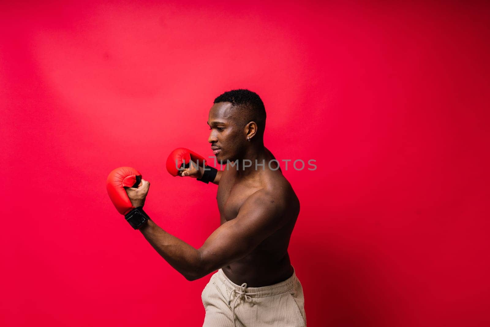 Young attractive African American male boxer with a bare torso, muscular body. Concept of training