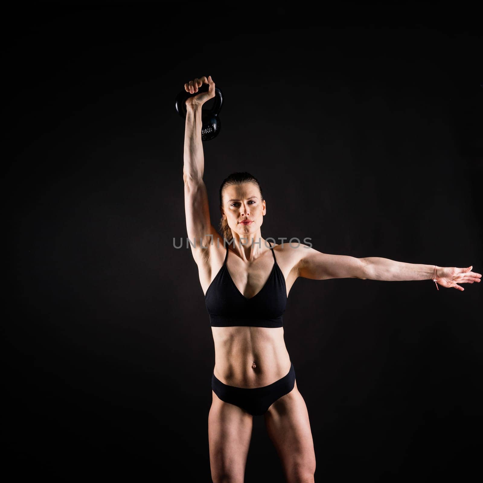 Slim, woman and kettlebell in workout for fitness, exercise and wellness with weight in studio. by Zelenin