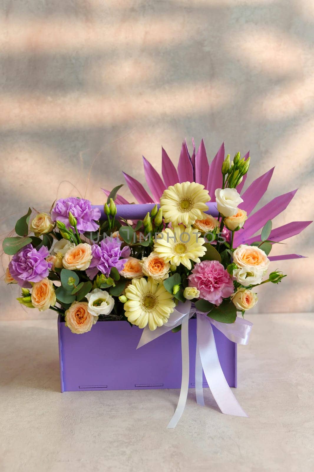 Vibrant bouquet of assorted flowers sits gracefully on a table, adding color and beauty to the space. Vertical photo