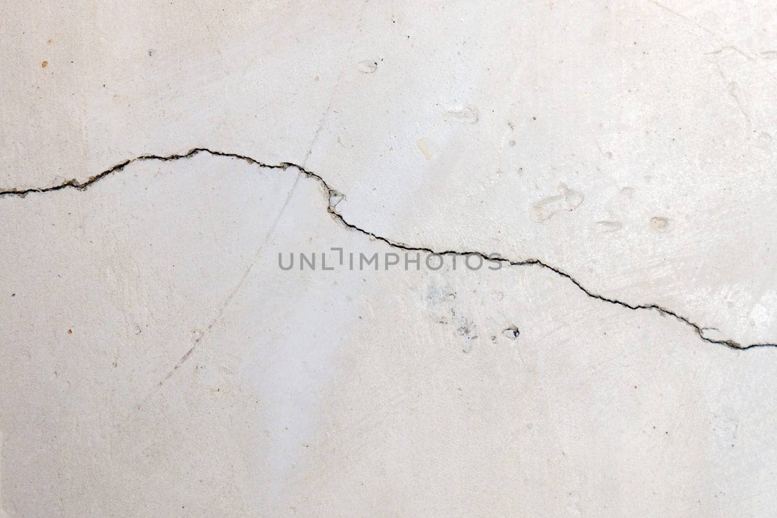 Cracked concrete wall covered with a gray cement surface as a background