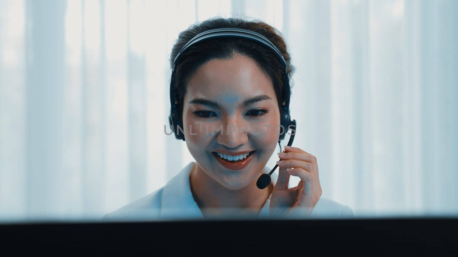 Businesswoman wearing vivancy headset working in office to support remote customer or colleague. Call center, telemarketing, customer support agent provide service on telephone video conference call