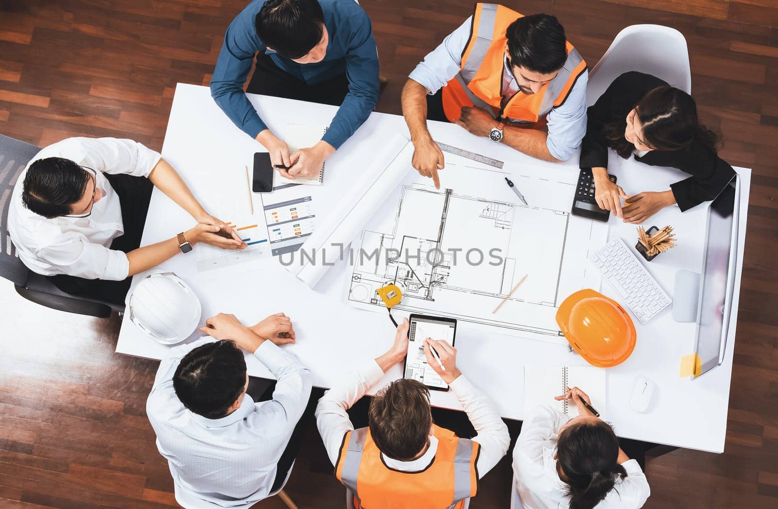 Top view banner of diverse group of civil engineer and client working together on architectural project, reviewing construction plan and building blueprint at meeting table. Prudent