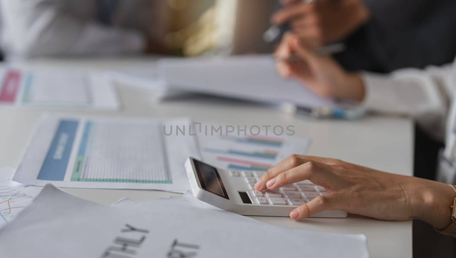 Close-up Shot of Businesswoman Hands Using Calculator for Financial Calculations in Modern Office Setting by wichayada