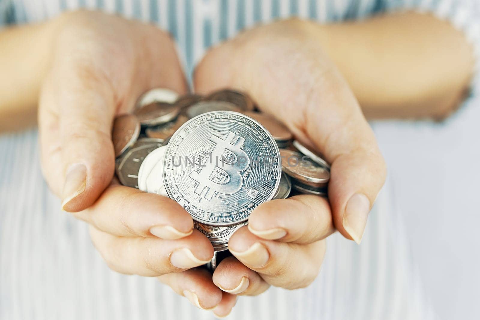 Bitcoin coin. Woman show her golden bitcoin on white background. Close-up.