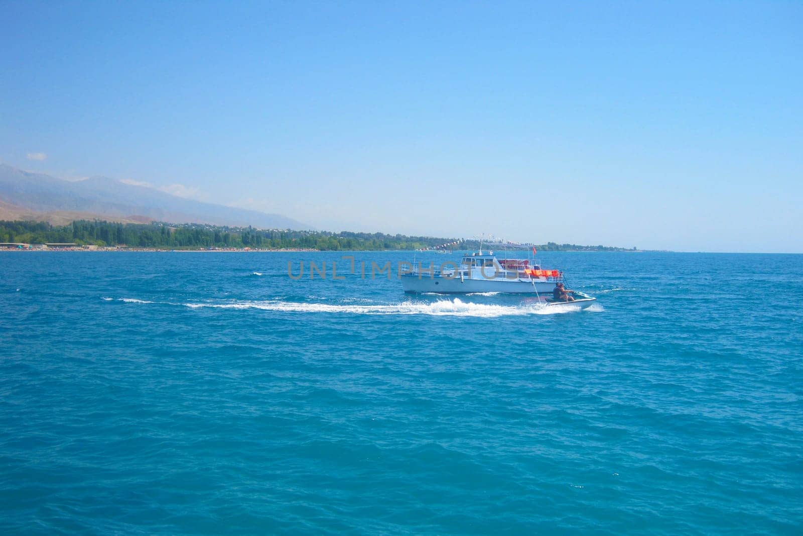 Jet ski in the sea on a Sunny day on the handicap of a small motor ship