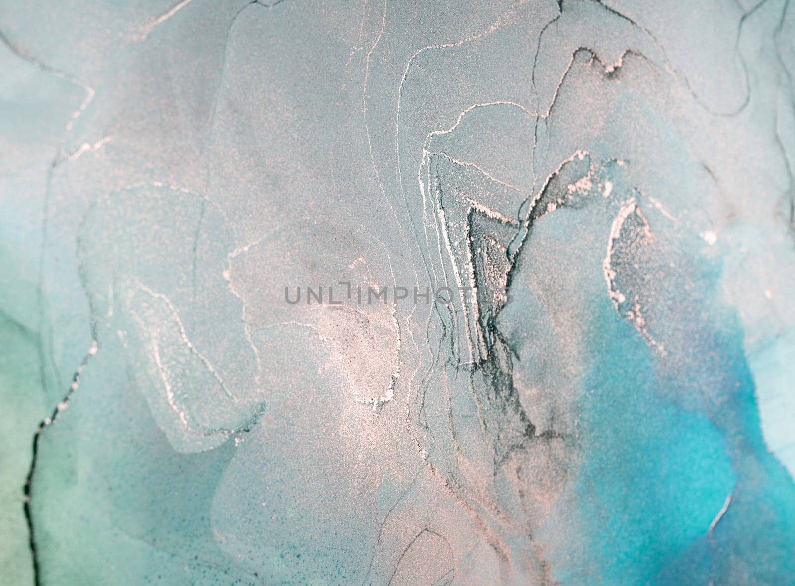 A close-up image showcasing abstract swirls of blue and silver ink, creating a mesmerizing and artistic pattern.