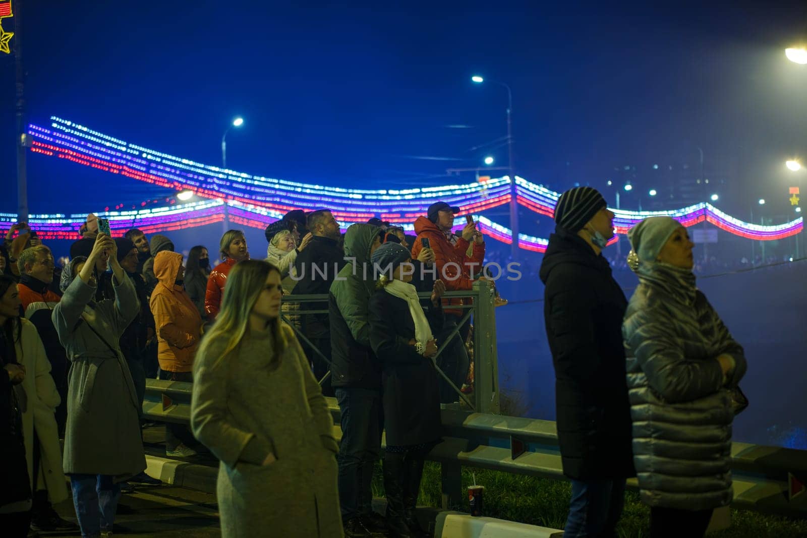 crowd of Russian people on the street are watching fireworks in a night sky in Tula, Russia - May 9, 2021