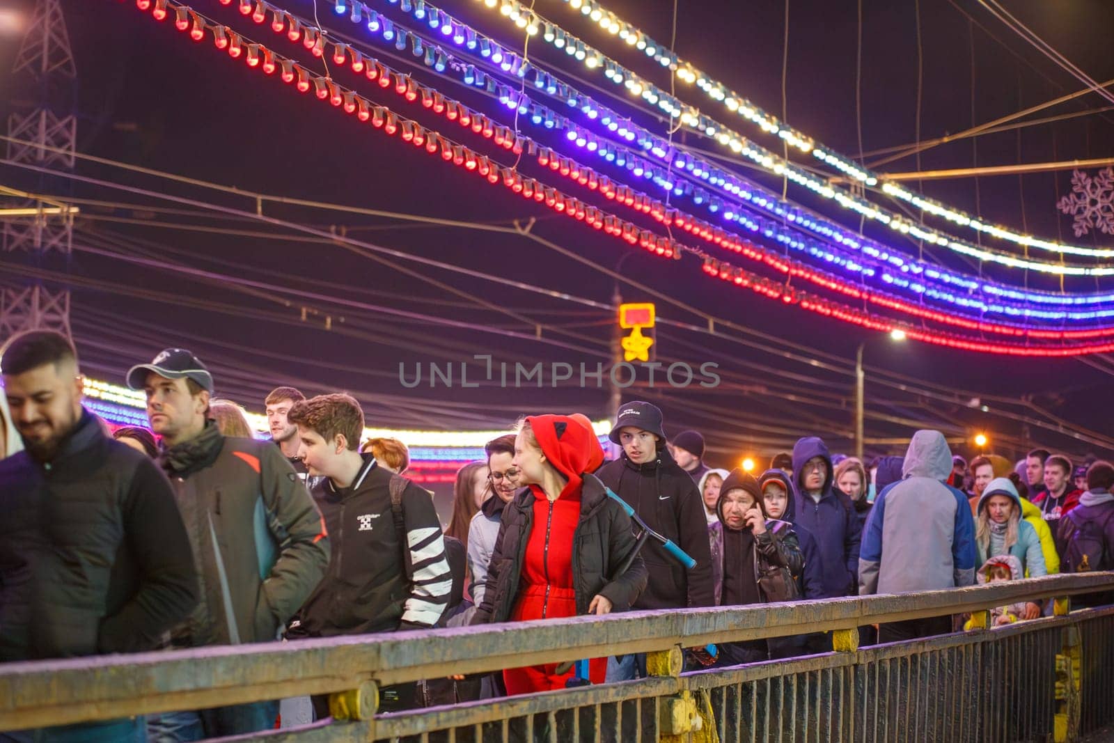 crowd of Russian people at road on the hill and bridge are watching fireworks in a night sky in Tula, Russia - May 9, 2021
