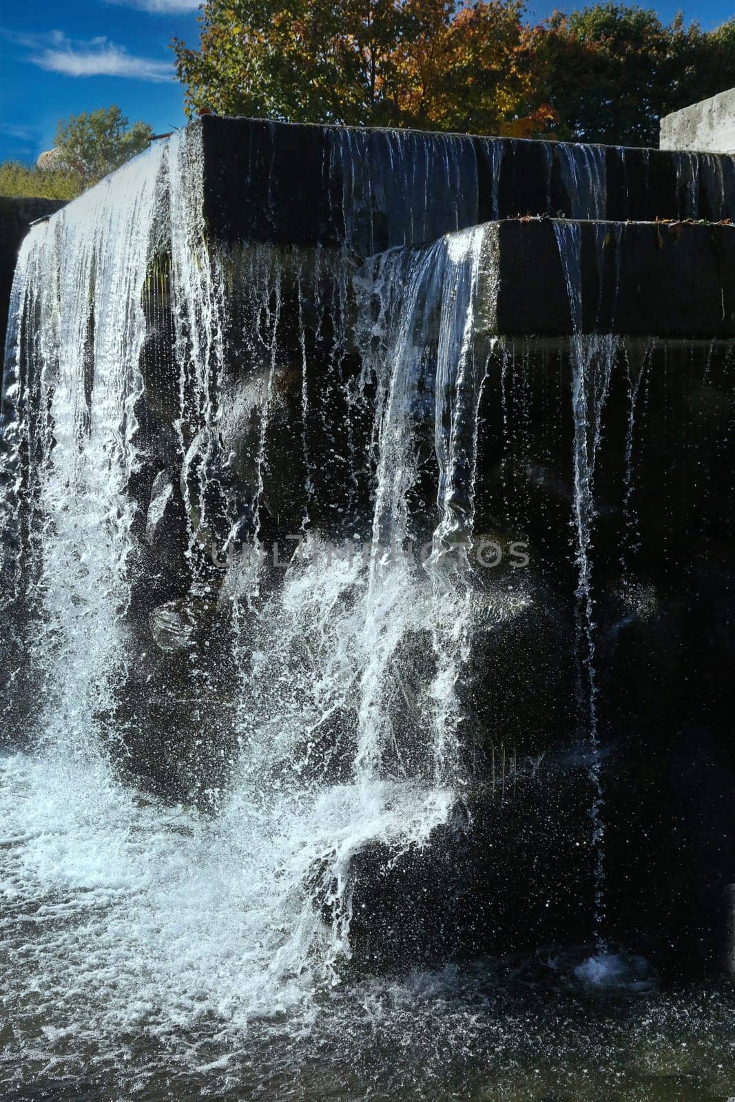 A fast flowing waterfall against the backdrop of autumn trees.