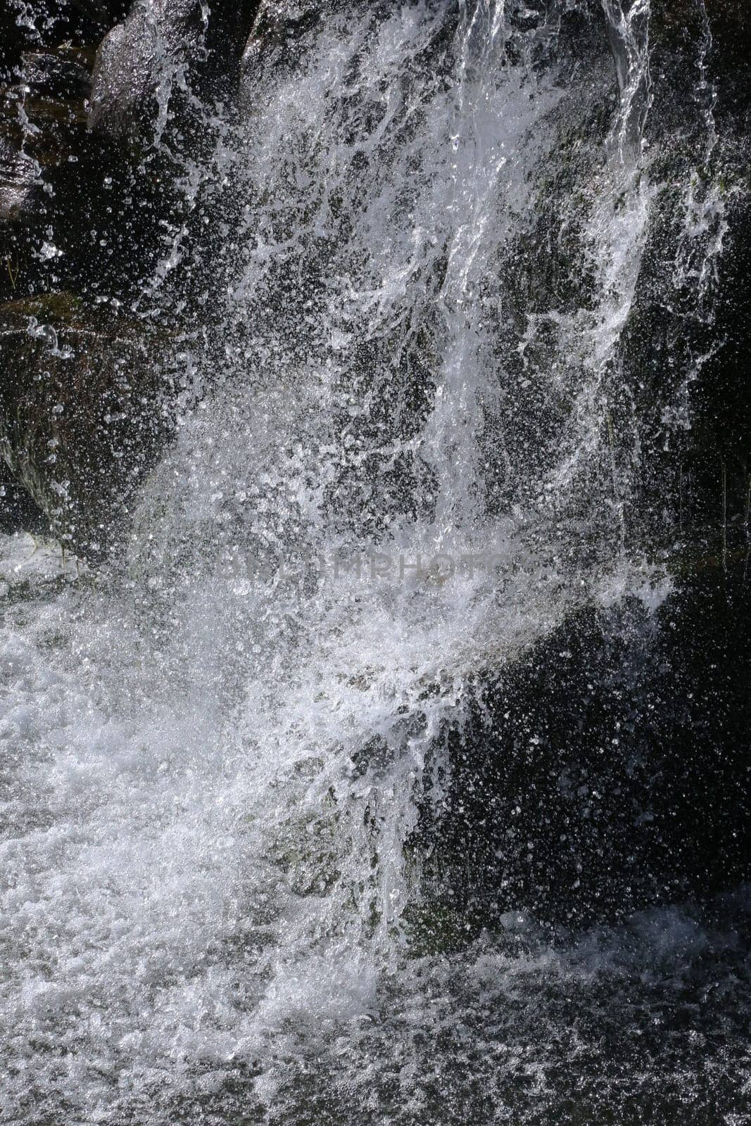 Moving stream of water. Heavily splashing water in fast flowing water.