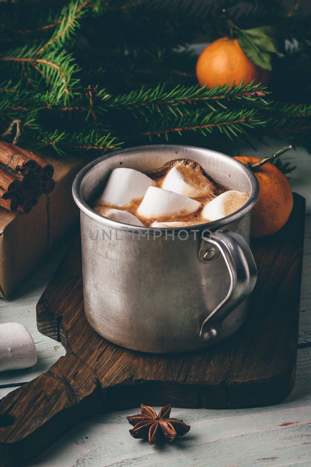 Rustic mug of hot chocolate with marshmallows on cutting board