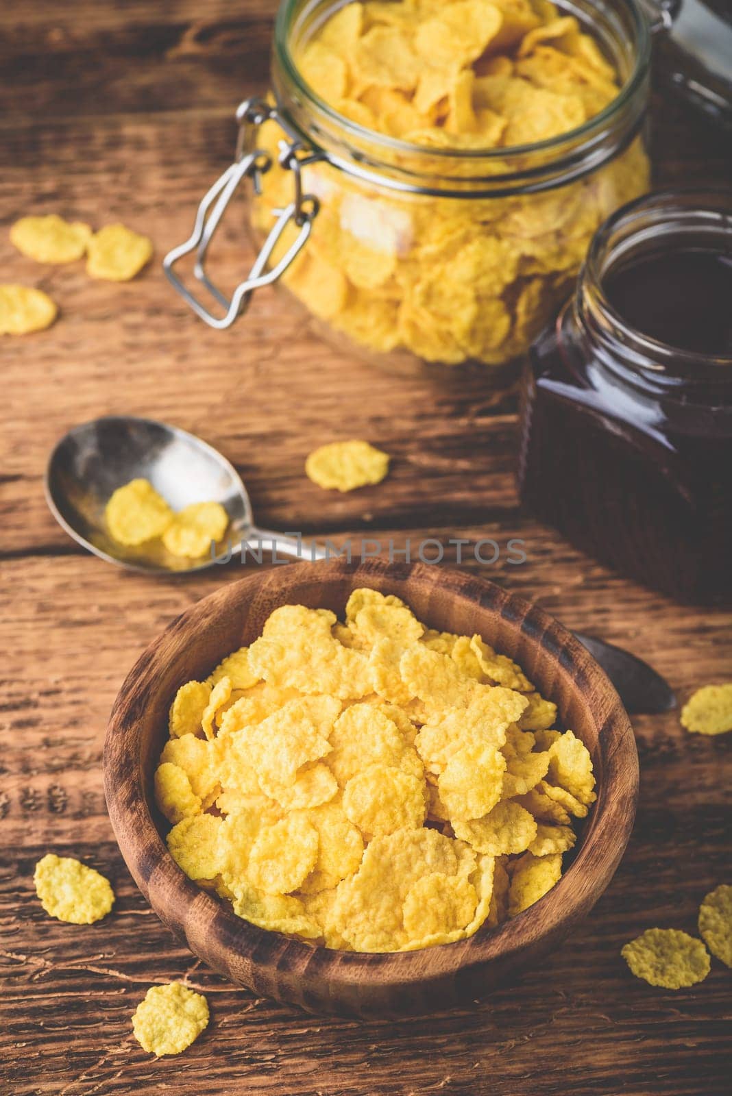 Breakfast with corn flakes, milk and berry jam