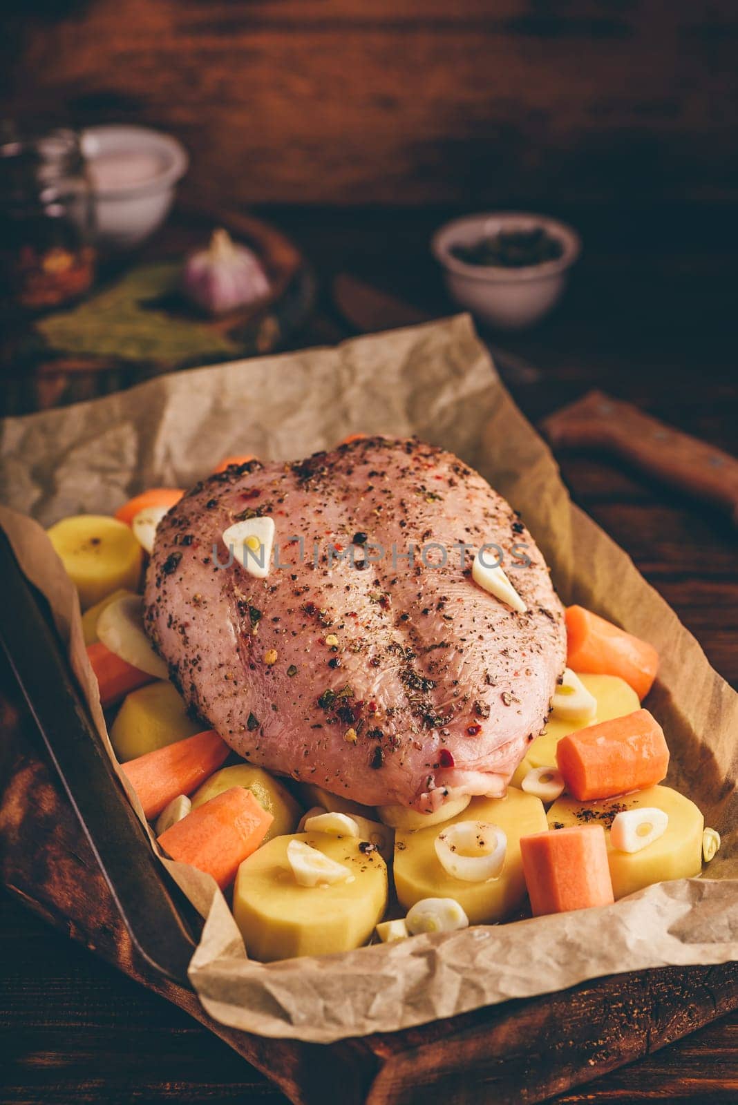 Seasoned chicken breast with carrot and potato ready for roast in oven