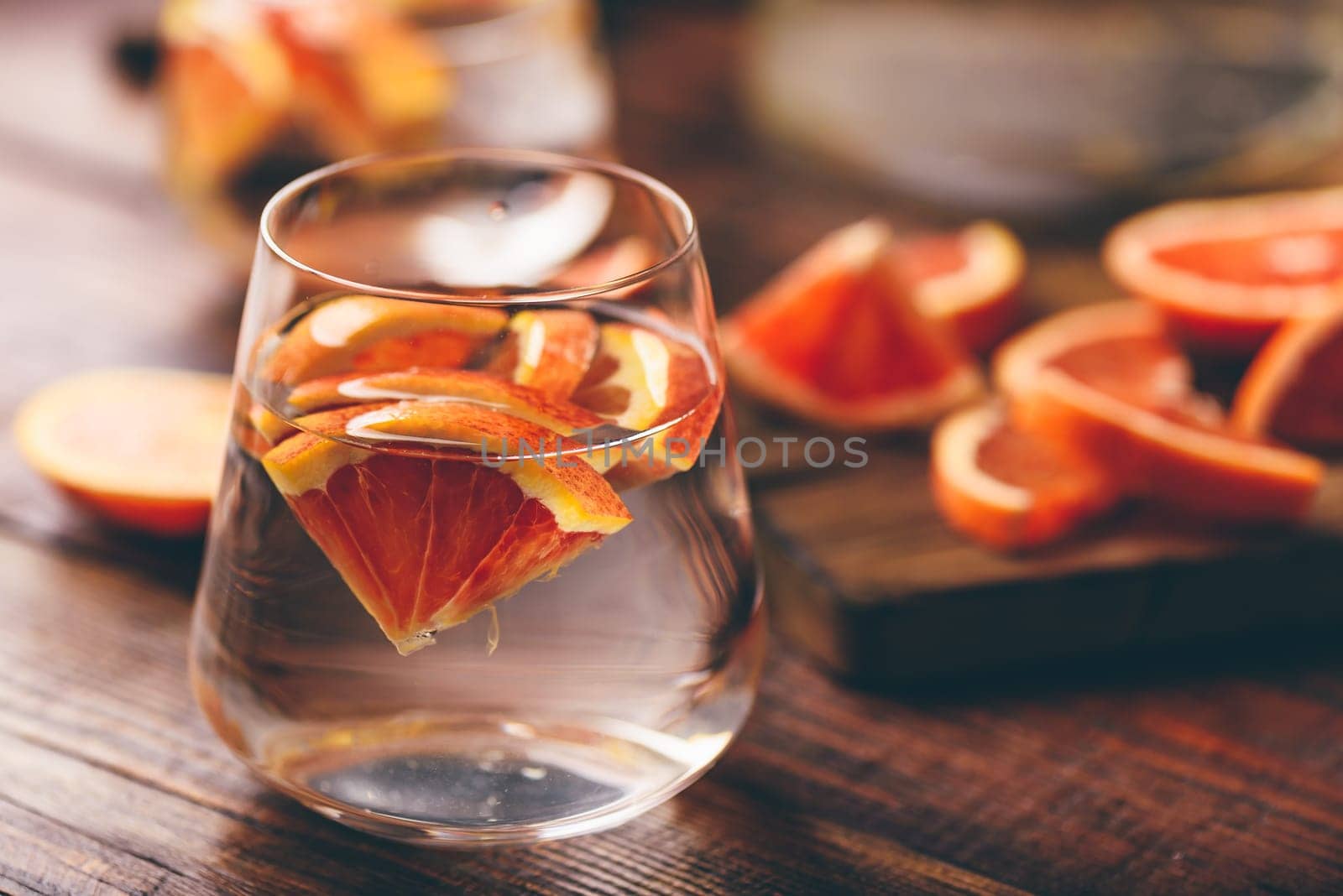 Infused water with bloody oranges in drinking glass