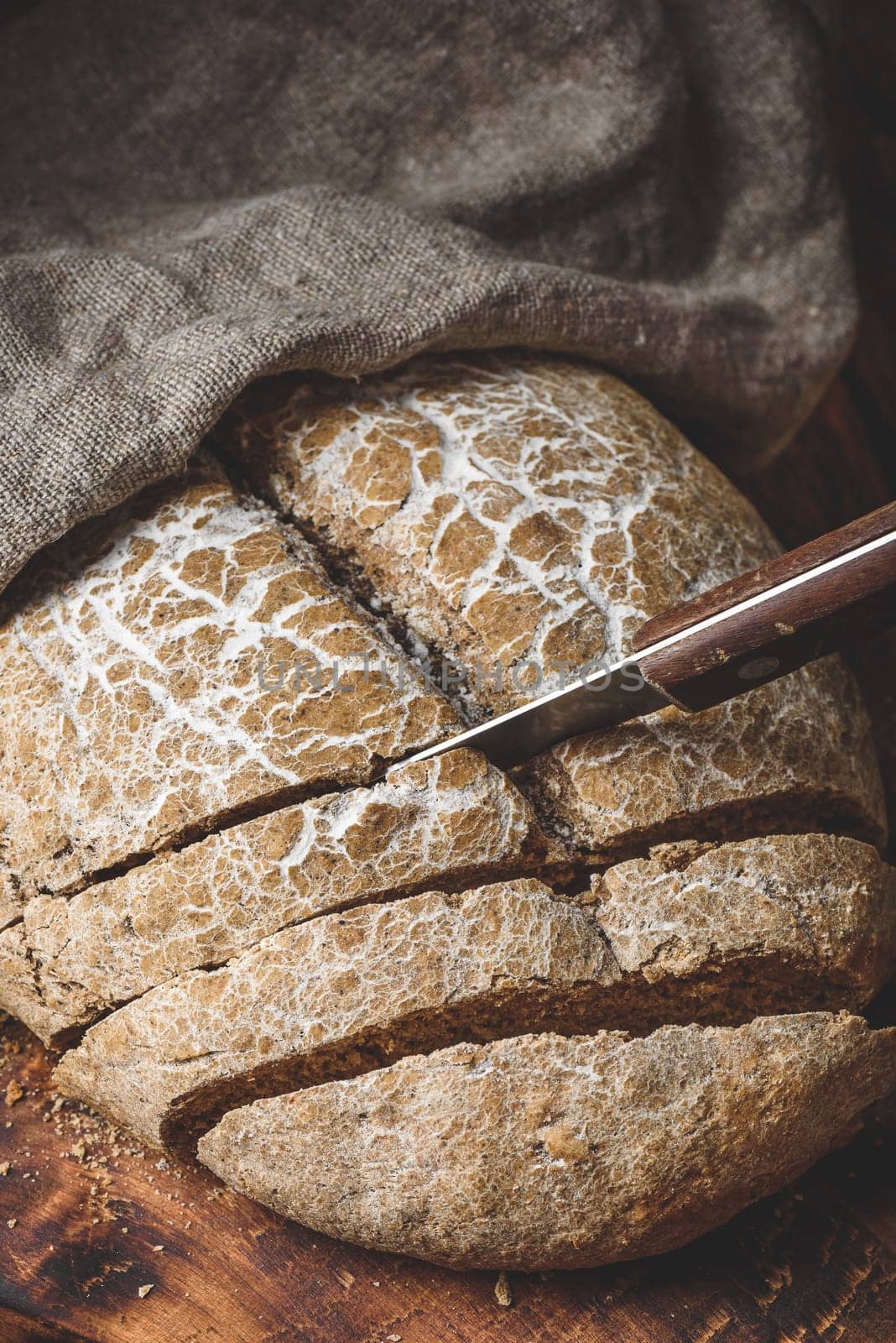 Sliced homemade rye bread on cutting board with knife