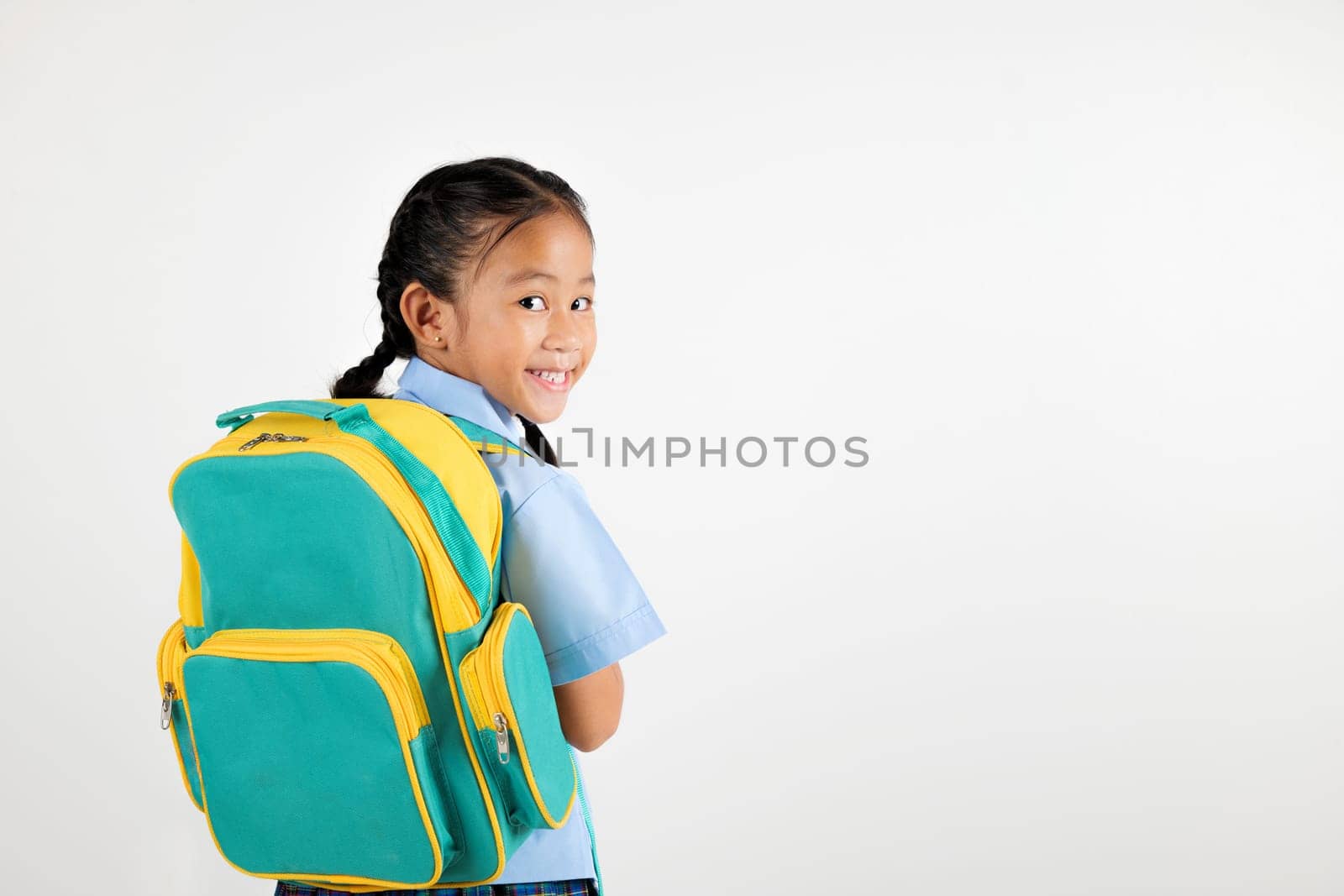 Portrait Back Asian smiling young girl kids kindergarten holding a green and yellow backpack studio shot isolated white background, happy cute little schoolgirl wears school uniform, back to school