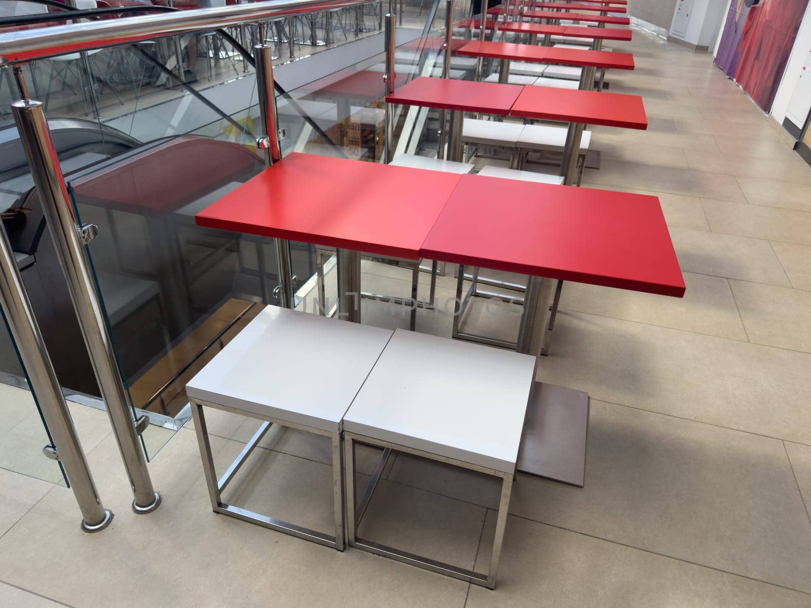 Red tables are empty in the cafe