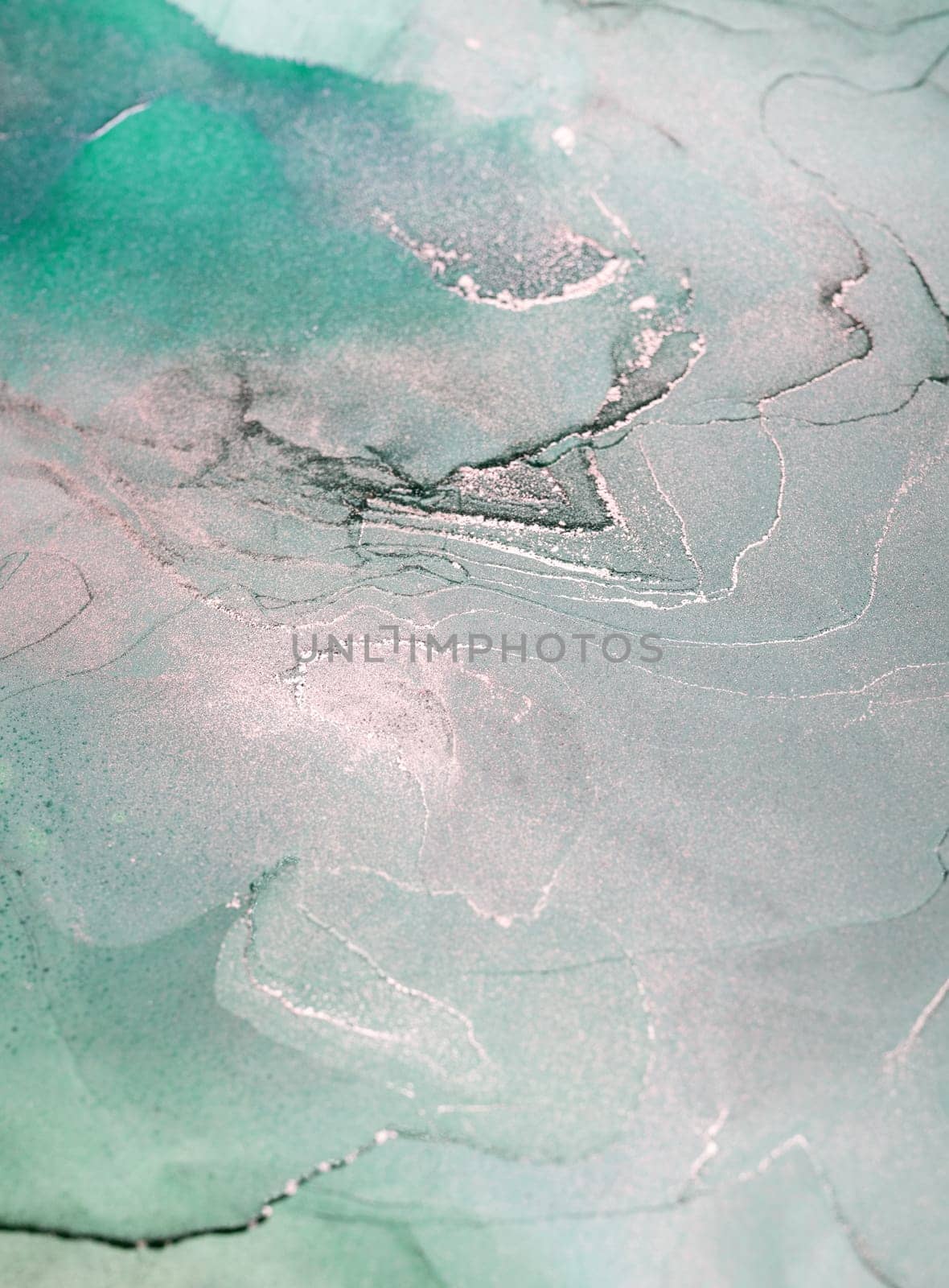 An abstract painting of green and silver ink swirling together in a fluid, organic pattern.