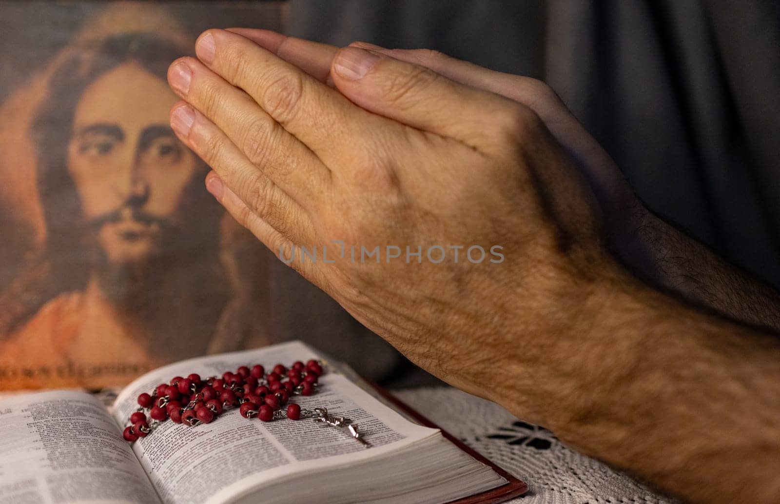 A man praying to the image of Christ. Bible and Rosary on his table by VeroDibe