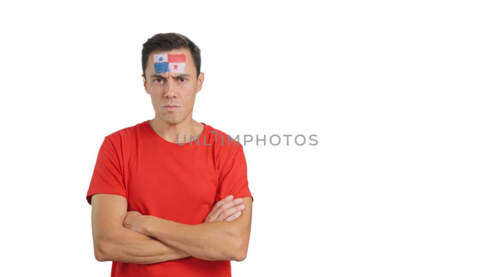 Dignified and serious man with panamanian flag painted on face looking the camera with dignity