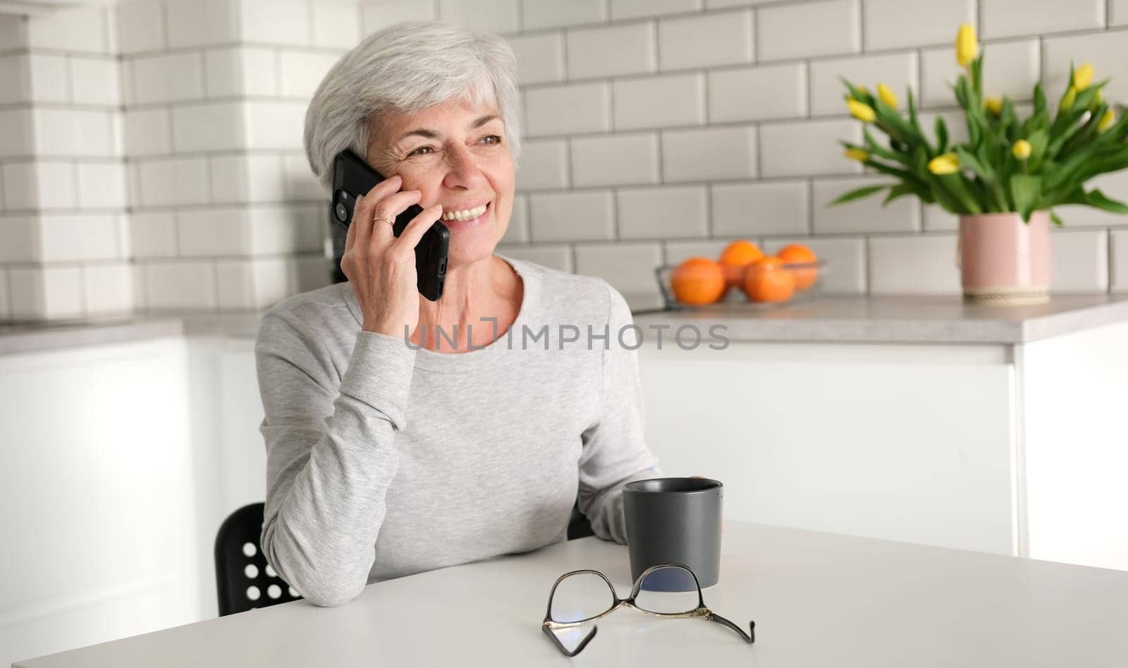 Cheerful Elderly Woman Chatting On The Phone With A Smile