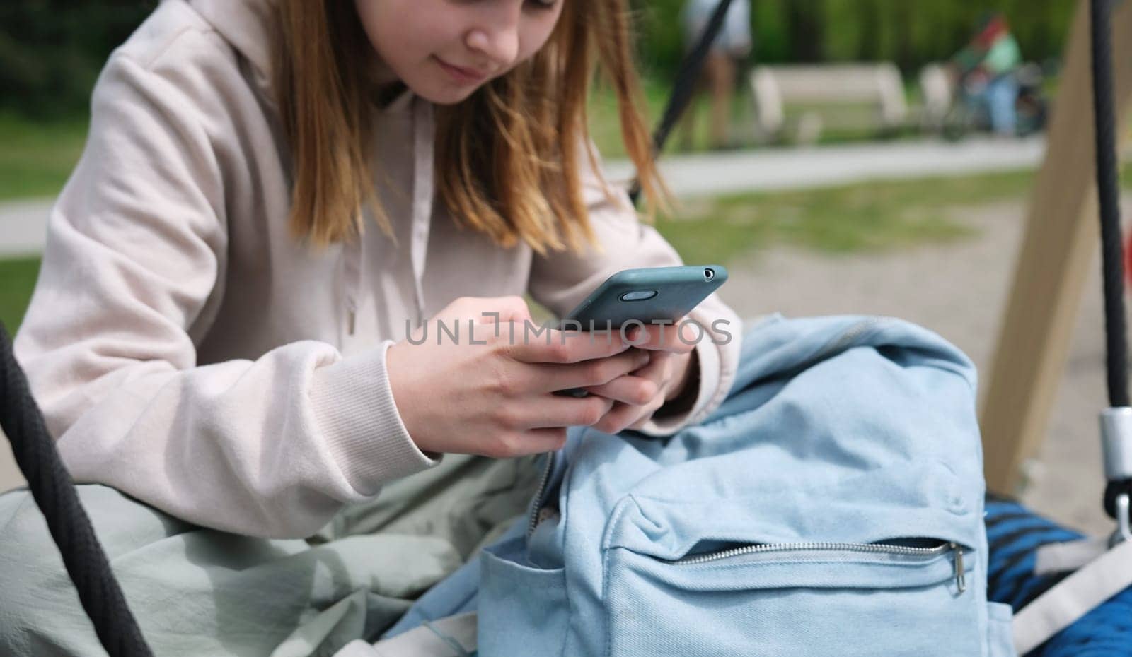 Schoolgirl On Smartphone Chatting With Friends On Social Media