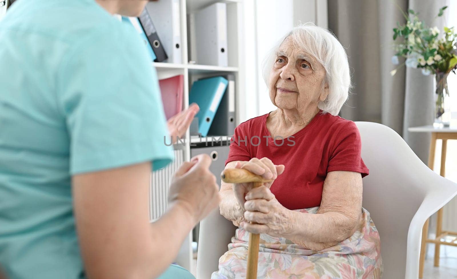 Medical Worker Holds Elderly Woman'S Hand And Calms Her Down