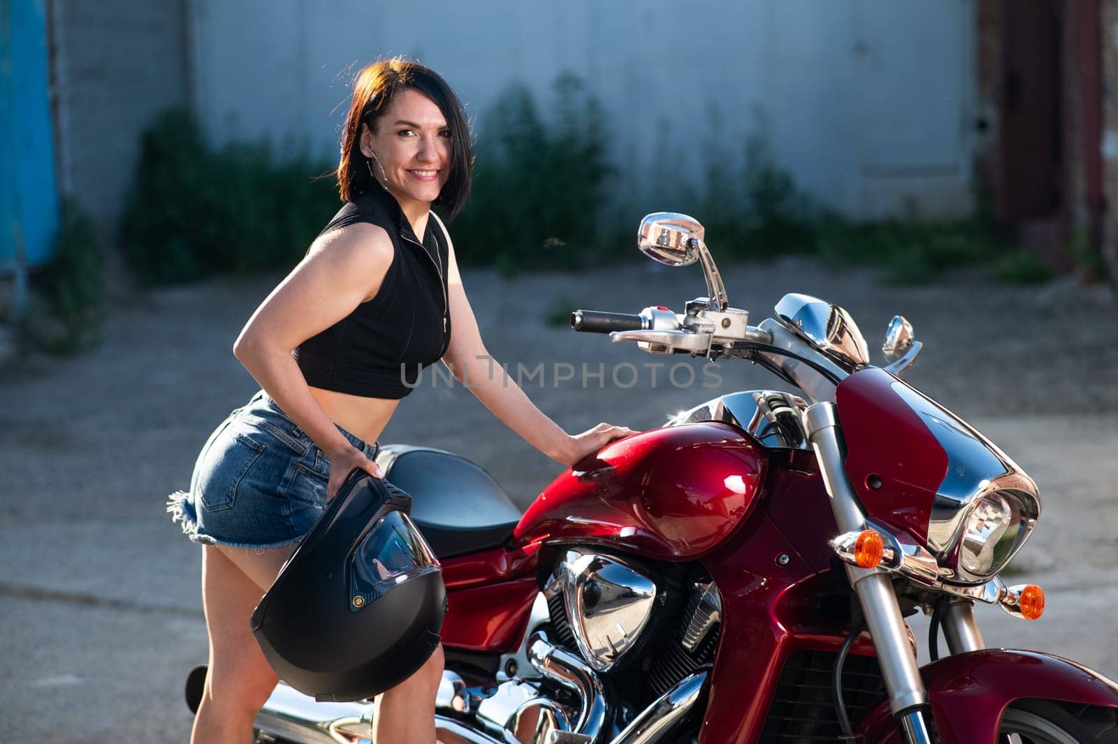 Brunette woman looks in the rearview mirror on a motorcycle. by mrwed54