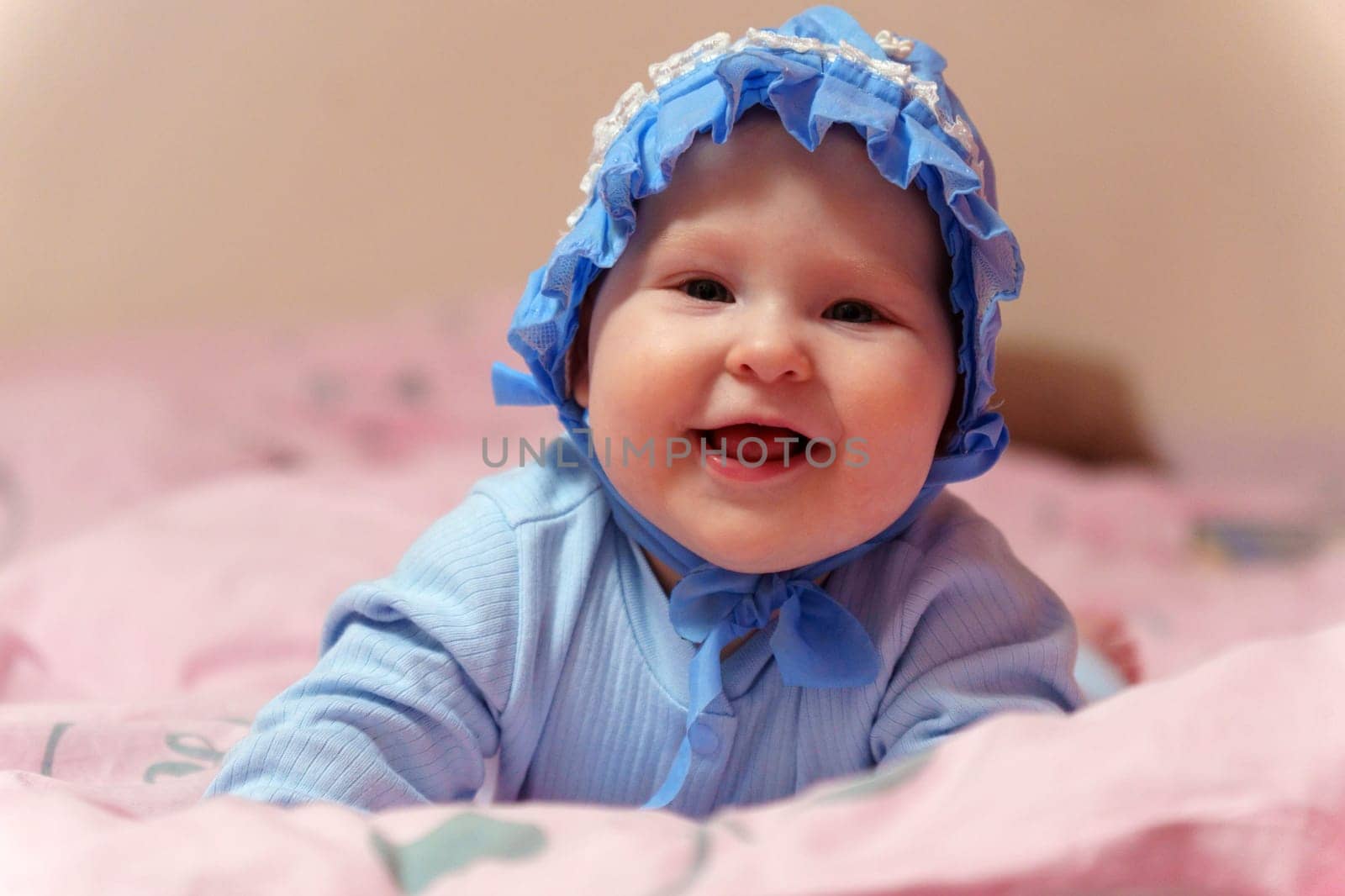 Dreamy Baby in Blue Bonnet on Pink Blanket. Selective focus