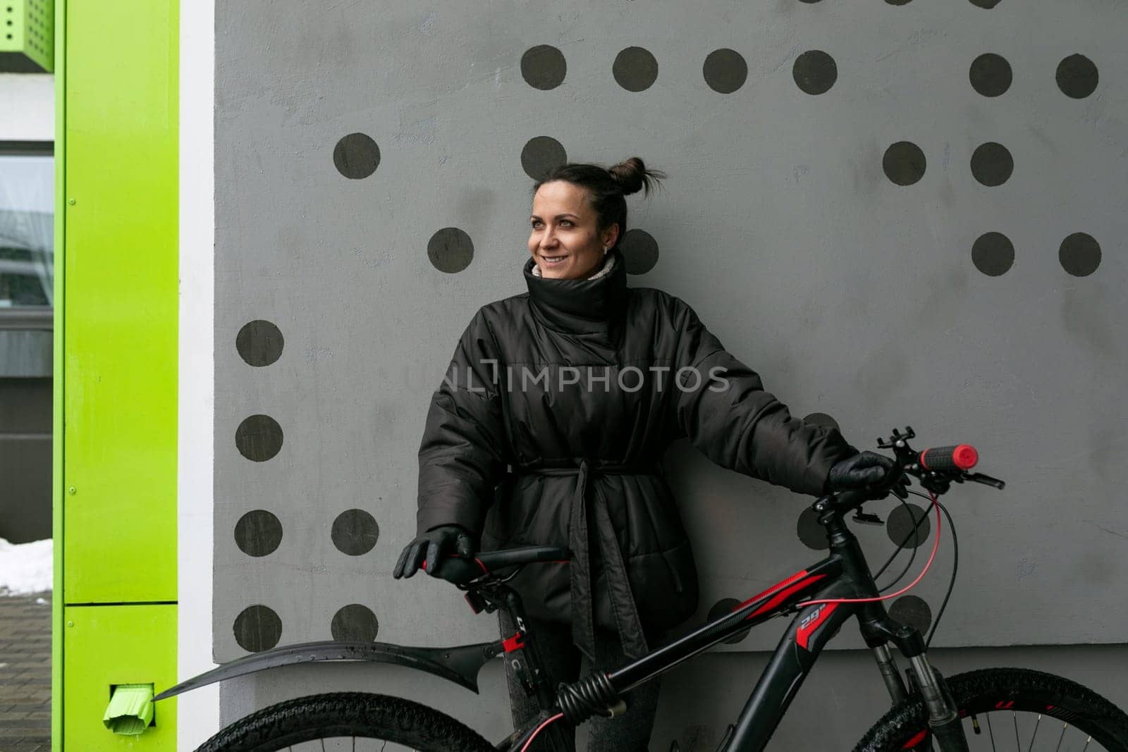 European young woman riding a bicycle on the street in winter.