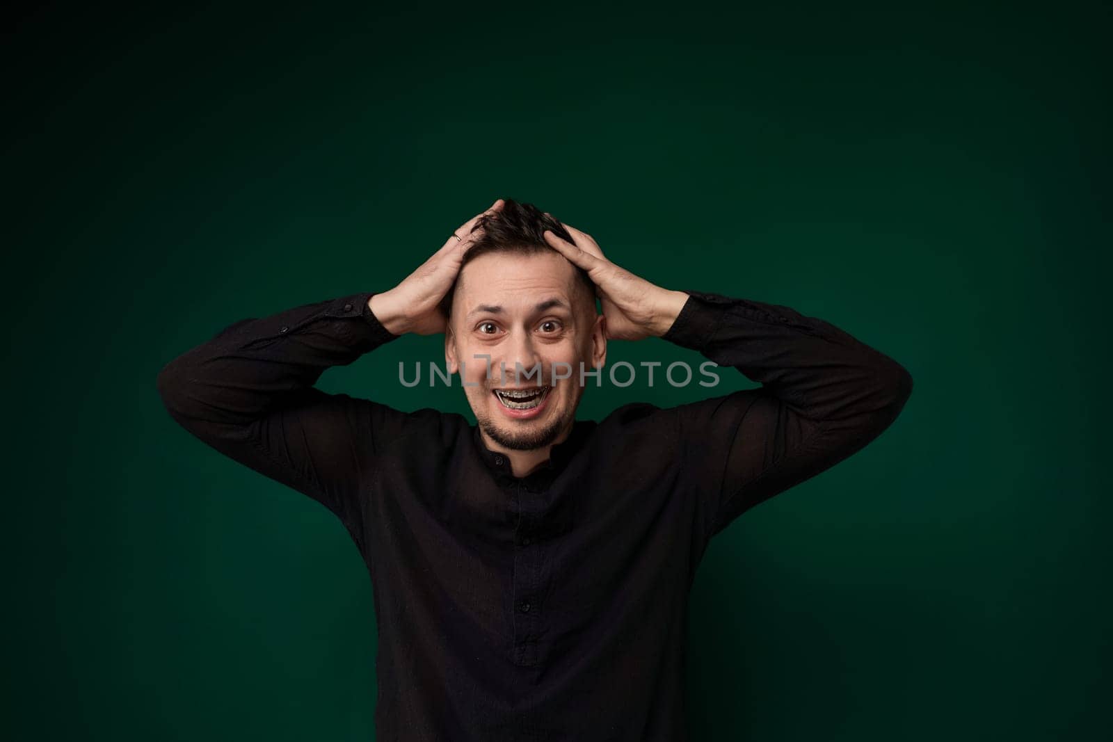 A man is standing with his hands on his head in an expression of distress or frustration. He appears to be deep in thought, contemplating a difficult situation or experiencing stress.