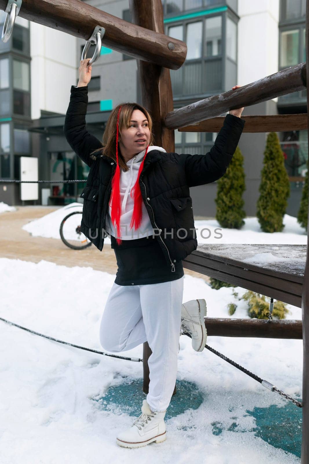 Young carefree woman having fun on the playground in winter.
